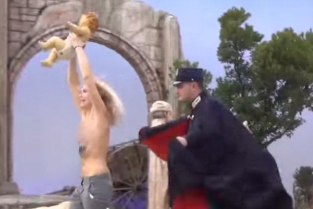 Członkini ruchu Femen ucieka z figurą watykańskiego Jezusa.