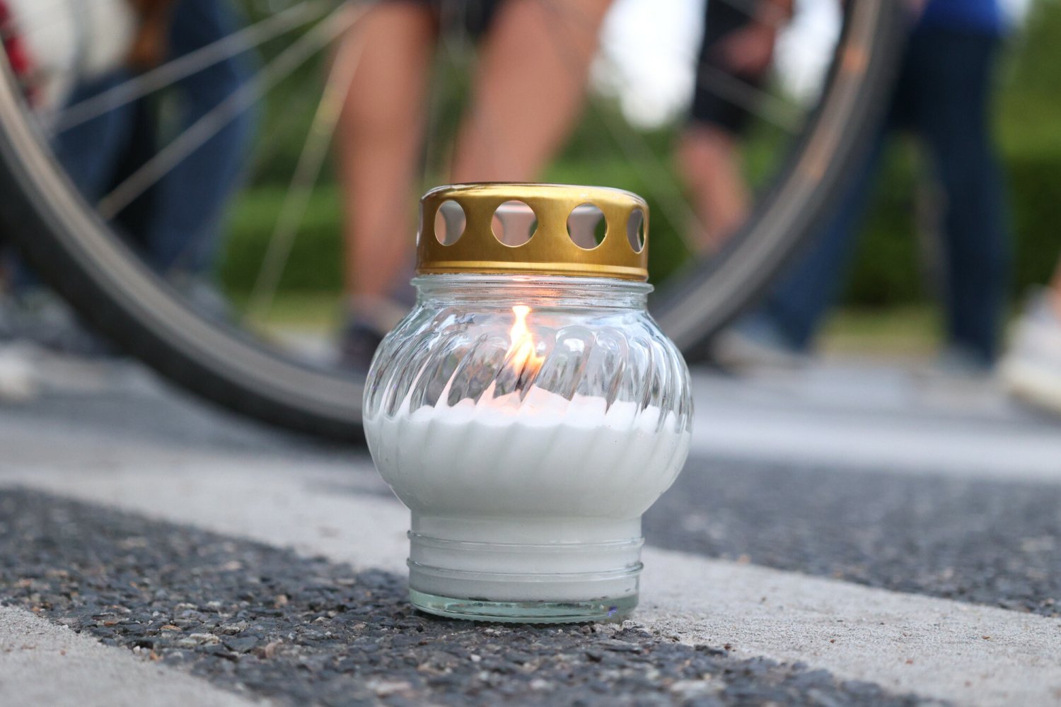 Zapalony znicz ustawiony na przejściu dla pieszych.