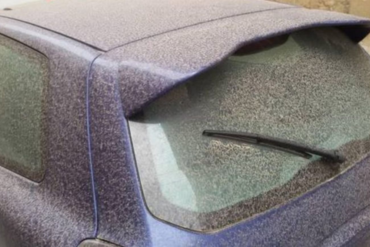 Samochód pokryty żółtym pyłem.