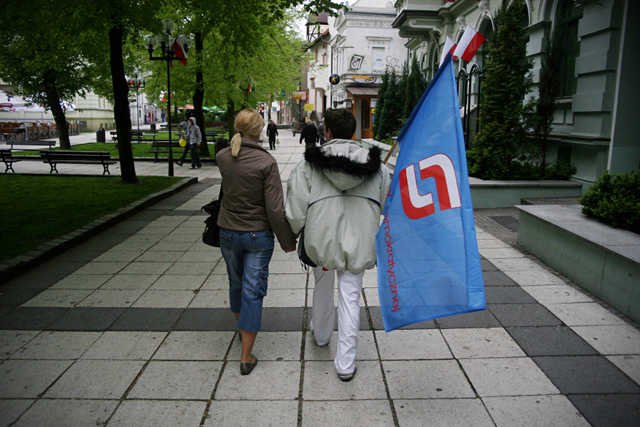 Para z flagą SLD podczas pochodu pierwszomajowego