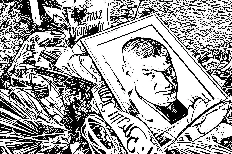 Zdjęcie i kwiaty na grobie Tomasza Komendy. Grób Tomasza Komendy, a na nim jego zdjęcie otoczone kwiatami.
