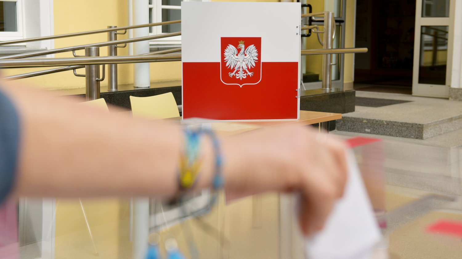 Ręka wrzucająca głos do urny.