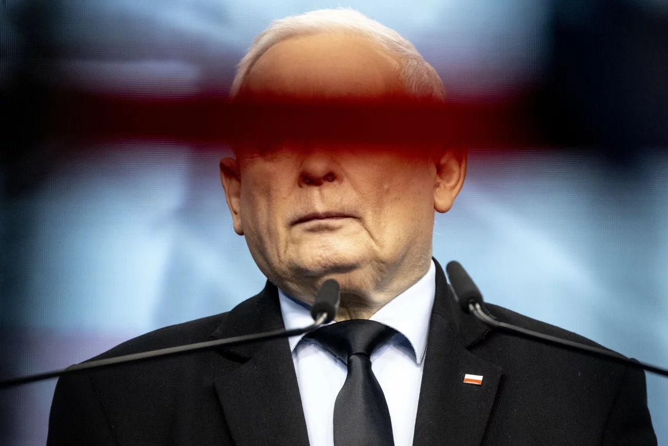 Jarosław Kaczyński przy mikrofonie na konferencji prasowej. Zdjęcie wykonane 6 czerwca 2024 roku. Prezes PiS Jarosław Kaczyński stojący przy mikrofonie. Zdjęcie zrobione jest w taki sposób, że jego oczy są niewidoczne, bo przesłania je pozioma przeszkoda.