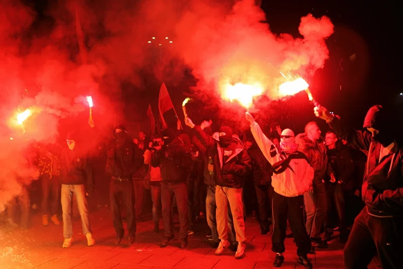Kibice odpalają race podczas Marszu Niepodległości.