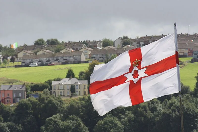Flaga północnoirlandzkich lojalistów, a w tle republikańska trójkolorowa flaga katolików. Ulster to jedno z najbardziej podzielonych miejsc w Europie