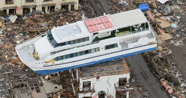 Ilustracja rozmiarów tsunami- statek wyniesiony ponad dachy domów.