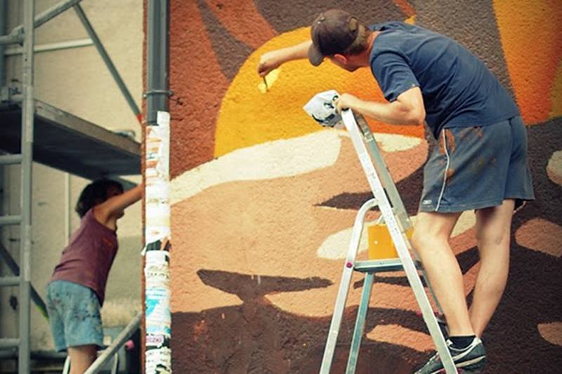 Anna Koźbiel i Adam Walas przy pracy nad muralem "Pomarańczarka" w podwarszawskiej Falenicy.