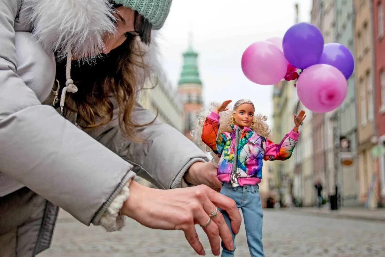 Fotografka Izabela Kwella układająca lalkę do sesji w centrum starego miasta Gdańska