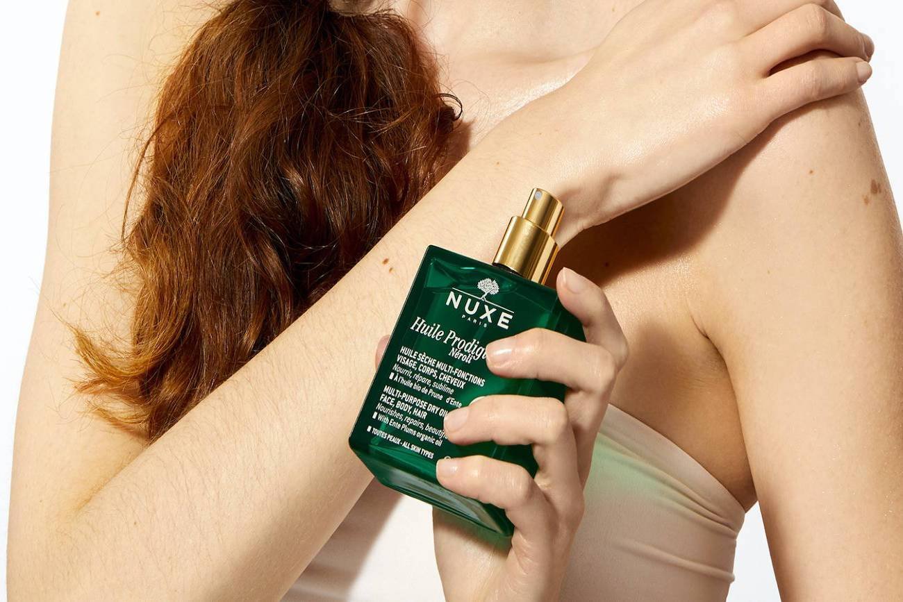 Kobieta trzymająca w dłoni olejek NUXE Huile Prodigieuse® Néroli