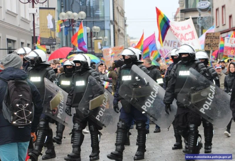 Uczestnicy marszu wchodzą na Rynek w eskorcie policjantów.
