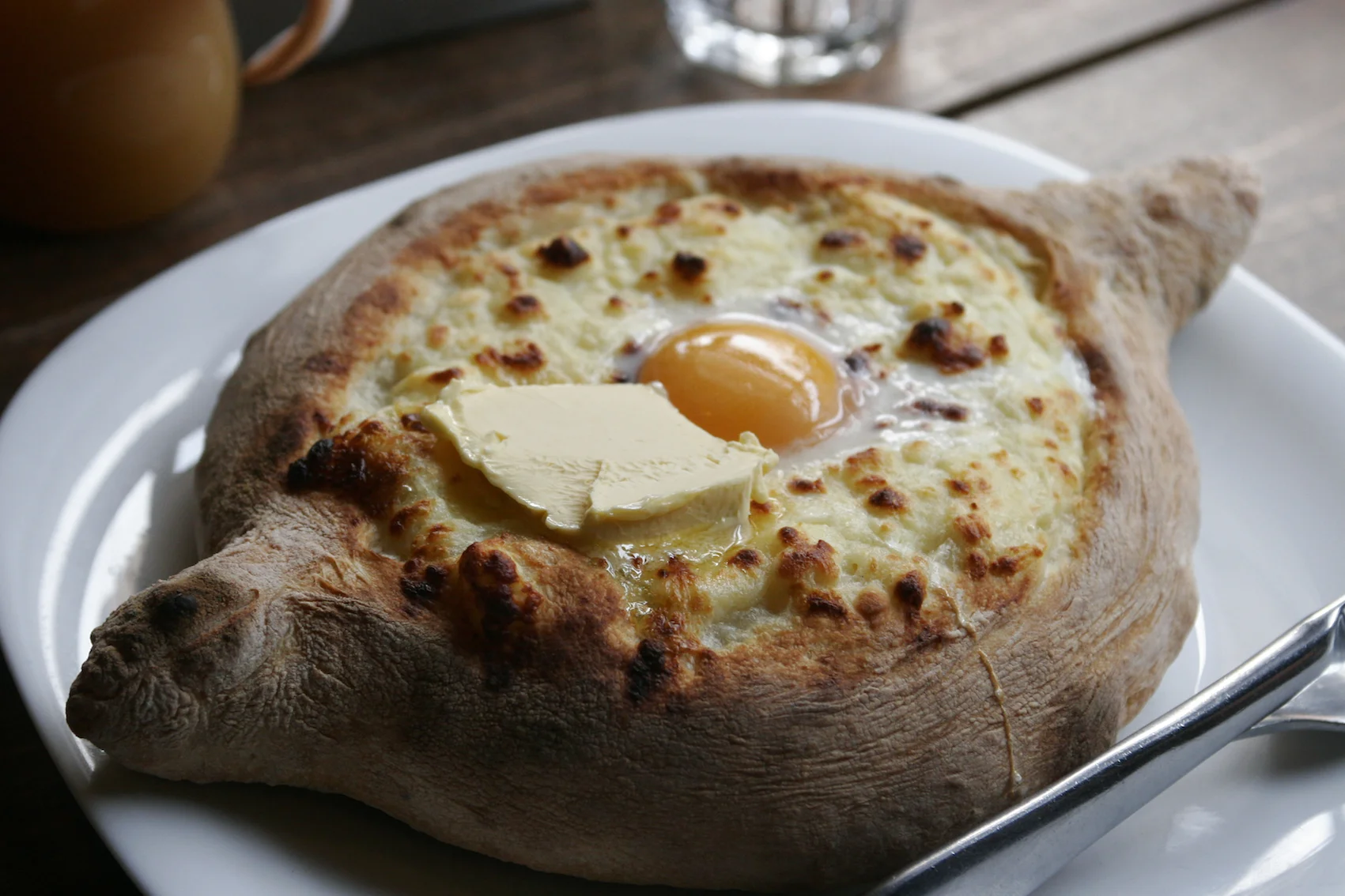 Adżarskie chaczapuri przypomina w smaku nieco pizzę. Przysmak je się palcami, odłamując spieczony brzeg i nabierając ciastem rozbełtane jajko sadzone z serem.