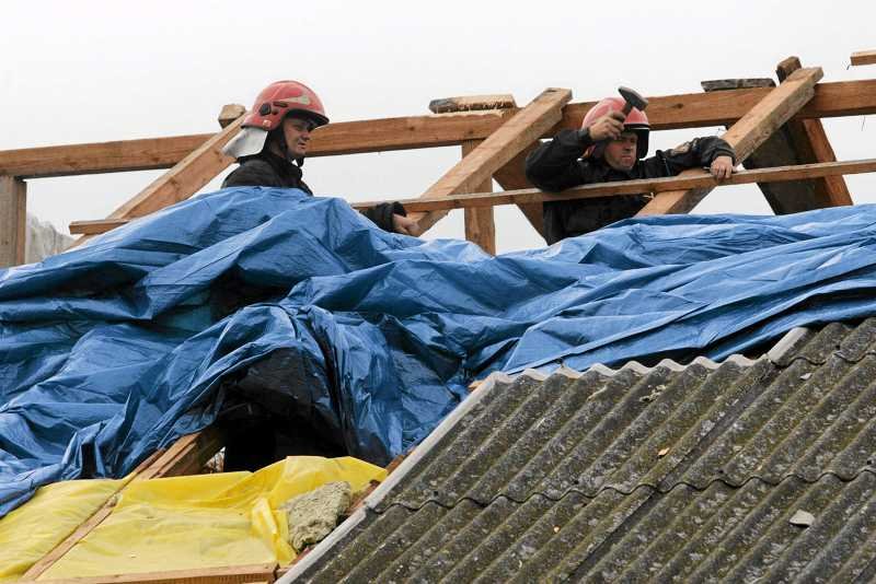 Strażacy zabezpieczają zniszczony podczas burzy dach