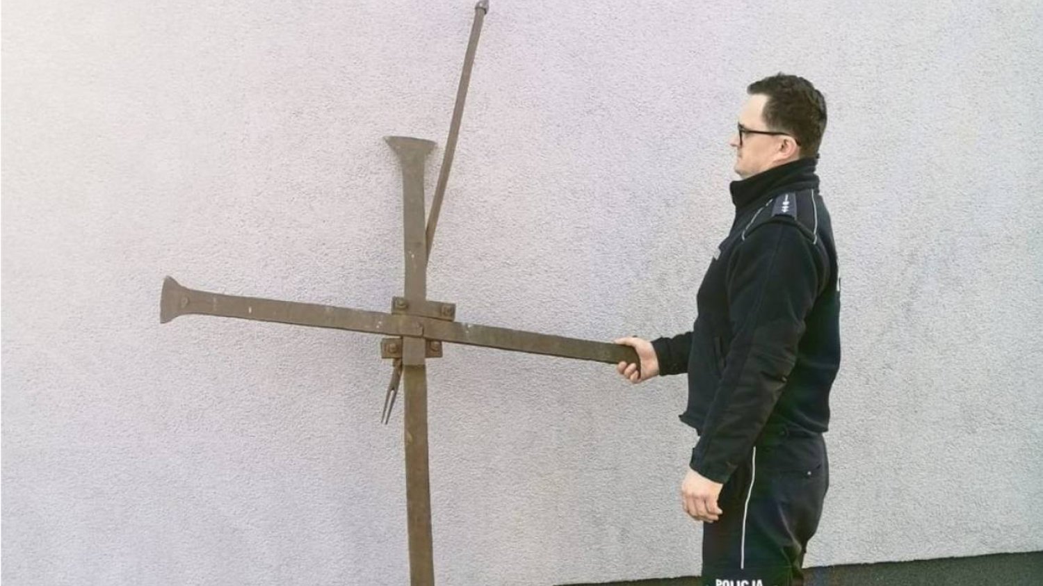 Policjant stoi przy krzyżu