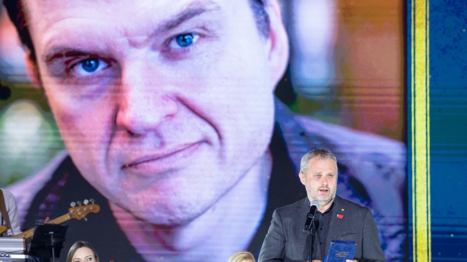 Bartosz Wieliński odbierający Medal Wolności w imieniu uwięzionego na Białorusi dziennikarza "Gazety Wyborczej" Andrzeja Poczobuta (wizerunek w tle). Bartosz Wieliński odbierający Medal Wolności w imieniu uwięzionego na Białorusi dziennikarza "Gazety Wyborczej" Andrzeja Poczobuta (wizerunek w tle).