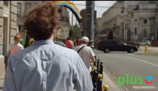 Kadr z reklamy Plusa. W tle widoczna jest tęcza, która stoi na placu Zbawiciela
