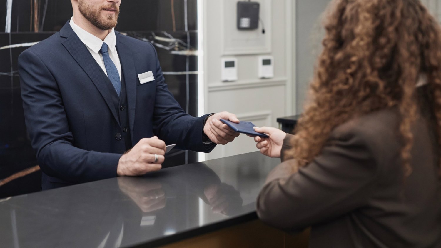 Nowe zasady w hotelach w Polsce. Nawet przy zameldowaniu czeka zaskoczenie Osoba melduje się w hotelu na recpecji.