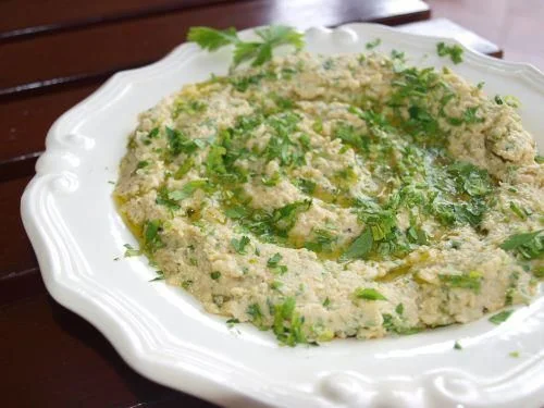 hummus, obficie posypany świeżą natką pietruszki.