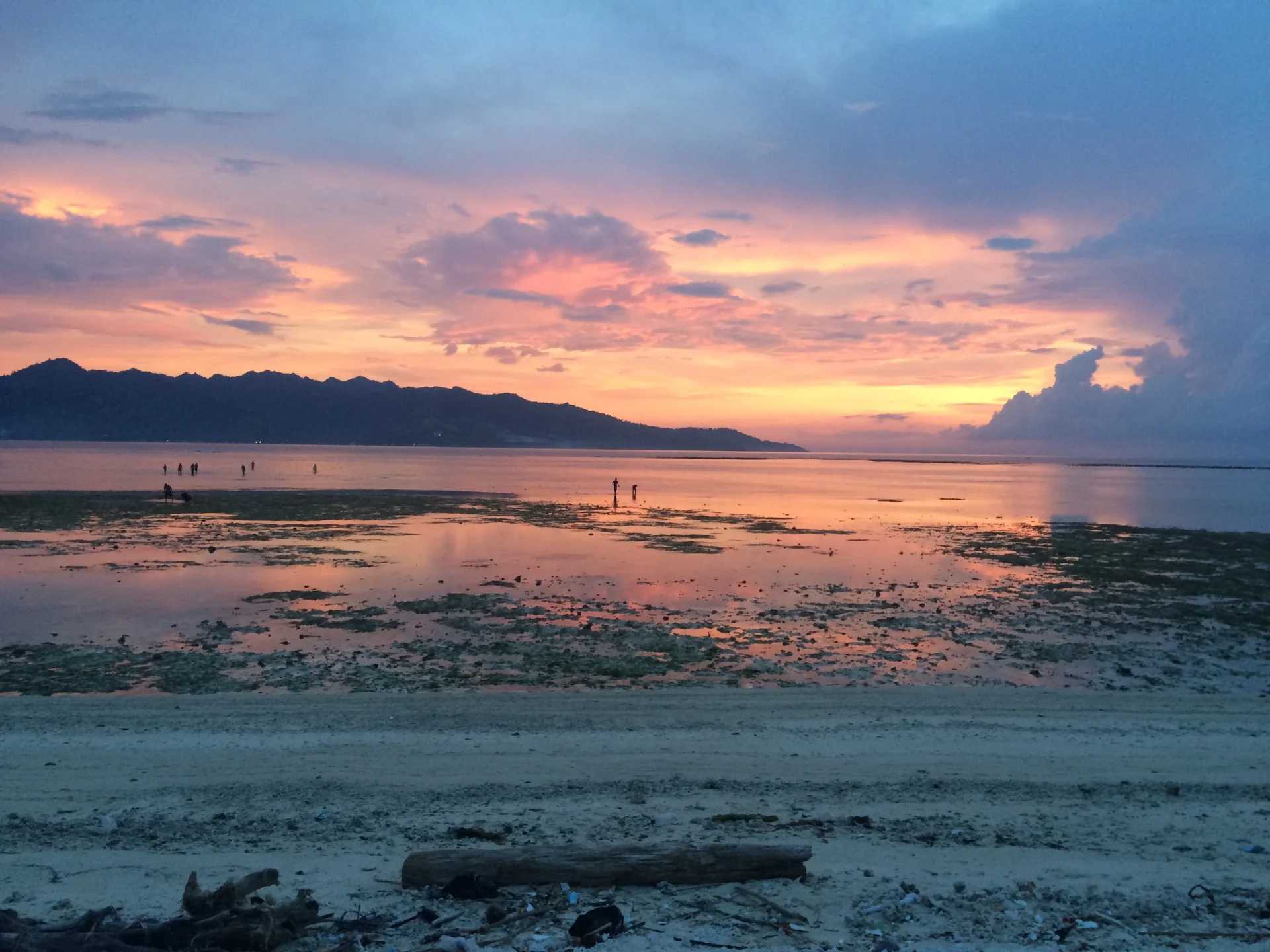 Niesamowite przedstawienie: ziemia, woda i ogień. Gili Meno i Gili Trawangan na horyzoncie.