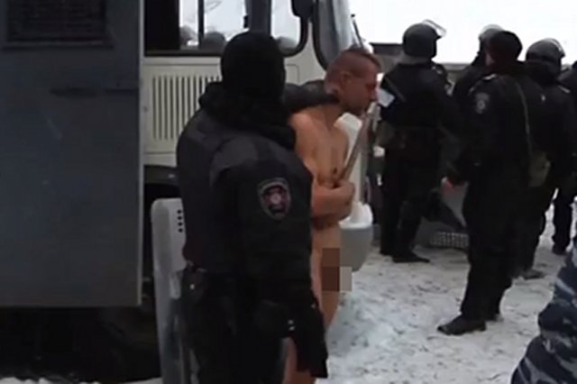 Milicjanci zmuszają nagiego mężczyznę do pozowania na mrozie