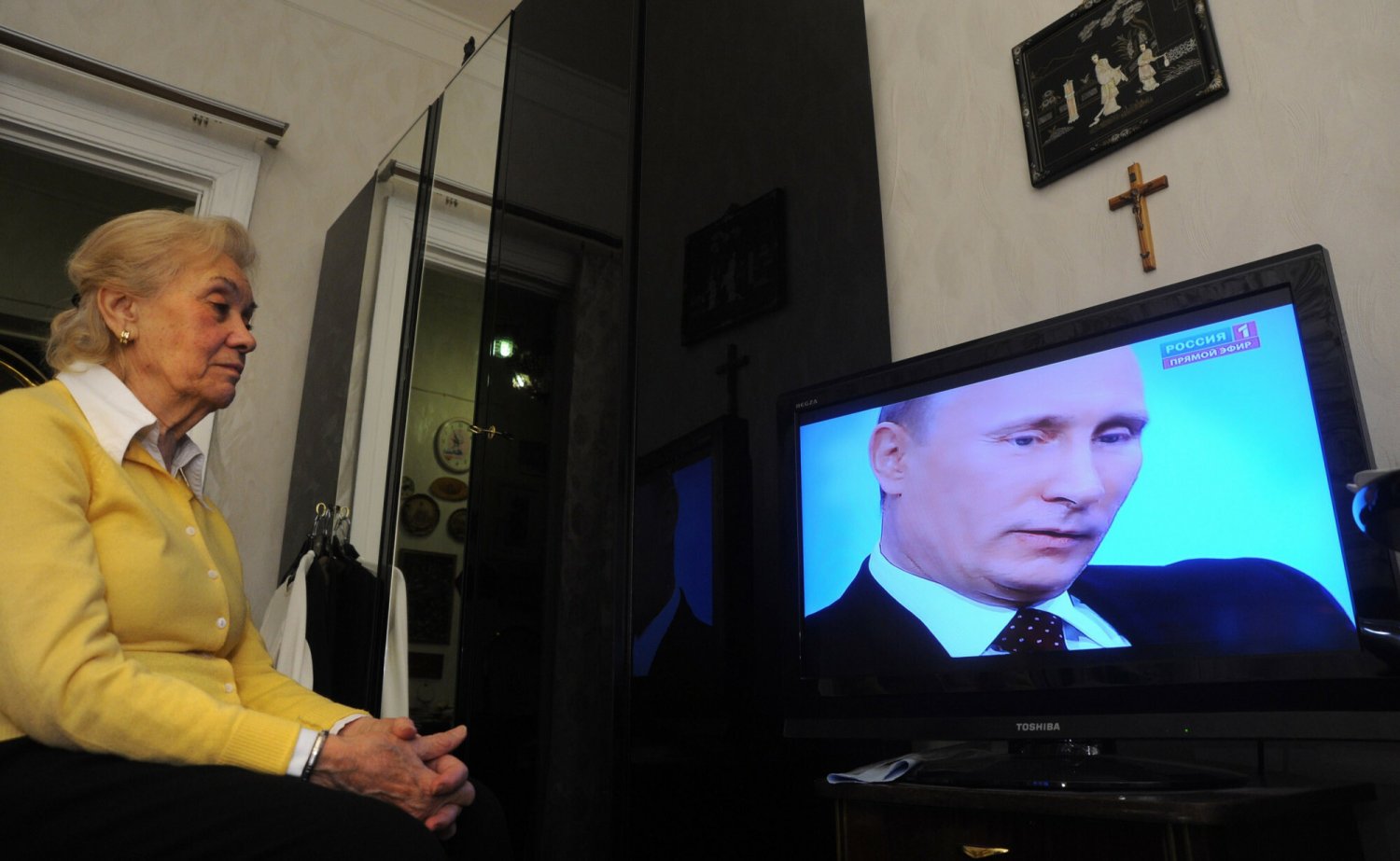 Mieszkanka Moskwy ogląda konferencję Władimira Putina. "Większość tych, którzy popierają Putina, nie siedzi w internecie. Oni od rana do wieczora oglądają państwową telewizję. Innej brak" - mówi prof. Nikołaj Iwanow.