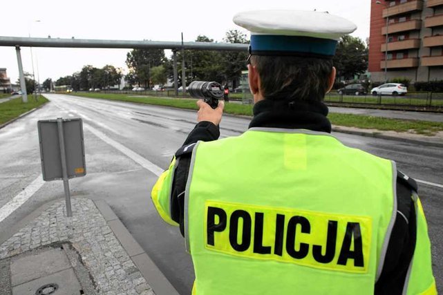 Policjant z ręcznym urządzeniem do mierzenia prędkości, popularnie nazywanym suszarką.