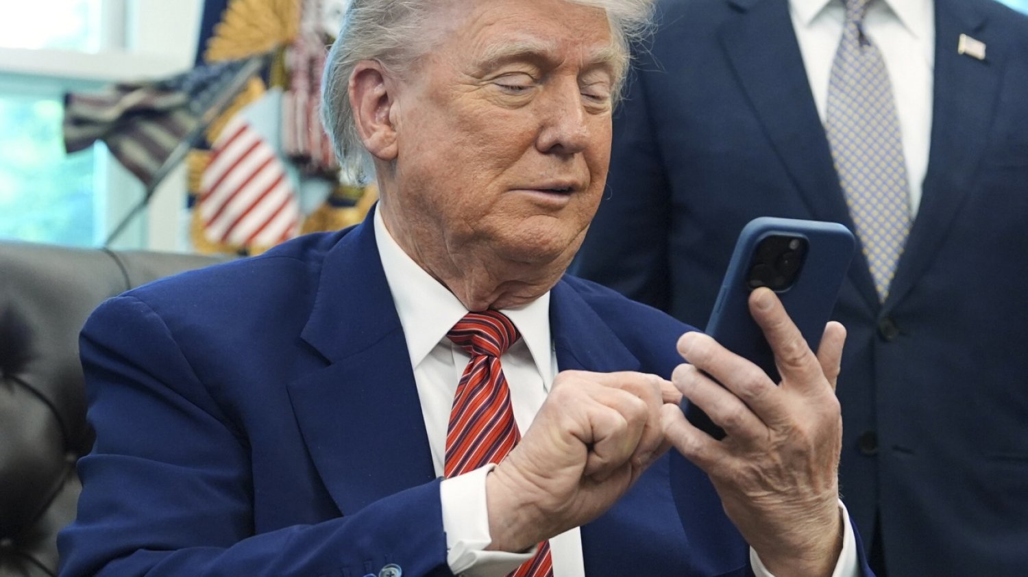 Prezydent USA Donald Trump ogłasza 50 proc. cła na Unię Europejską. To wojna handlowa. Wiadomo, od kiedy cła zaczną obowiązywać. Donald Trump w gabinecie owalnym korzystający z telefonu komórkowego.
