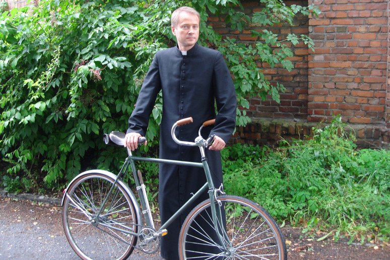 Ojciec Mateusz z nieodłącznym rowerem.