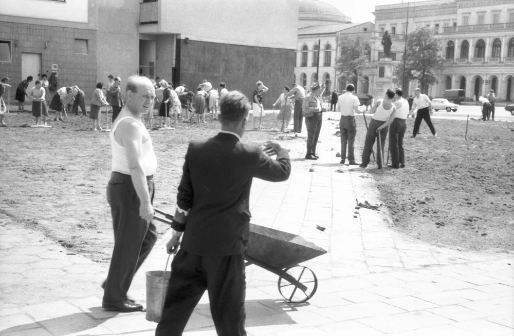 Mężczyźni i kobiety porządkujący trawnik na placu Dzierżyńskiego, 1963-09.