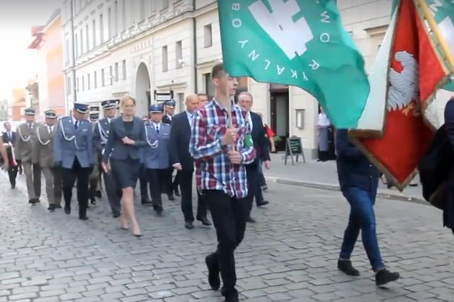 Przed oficjelami defilowało dwóch młodzieńców z flagami ONR.