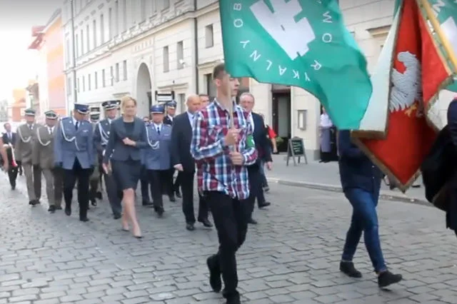 Przed oficjelami defilowało dwóch młodzieńców z flagami ONR.