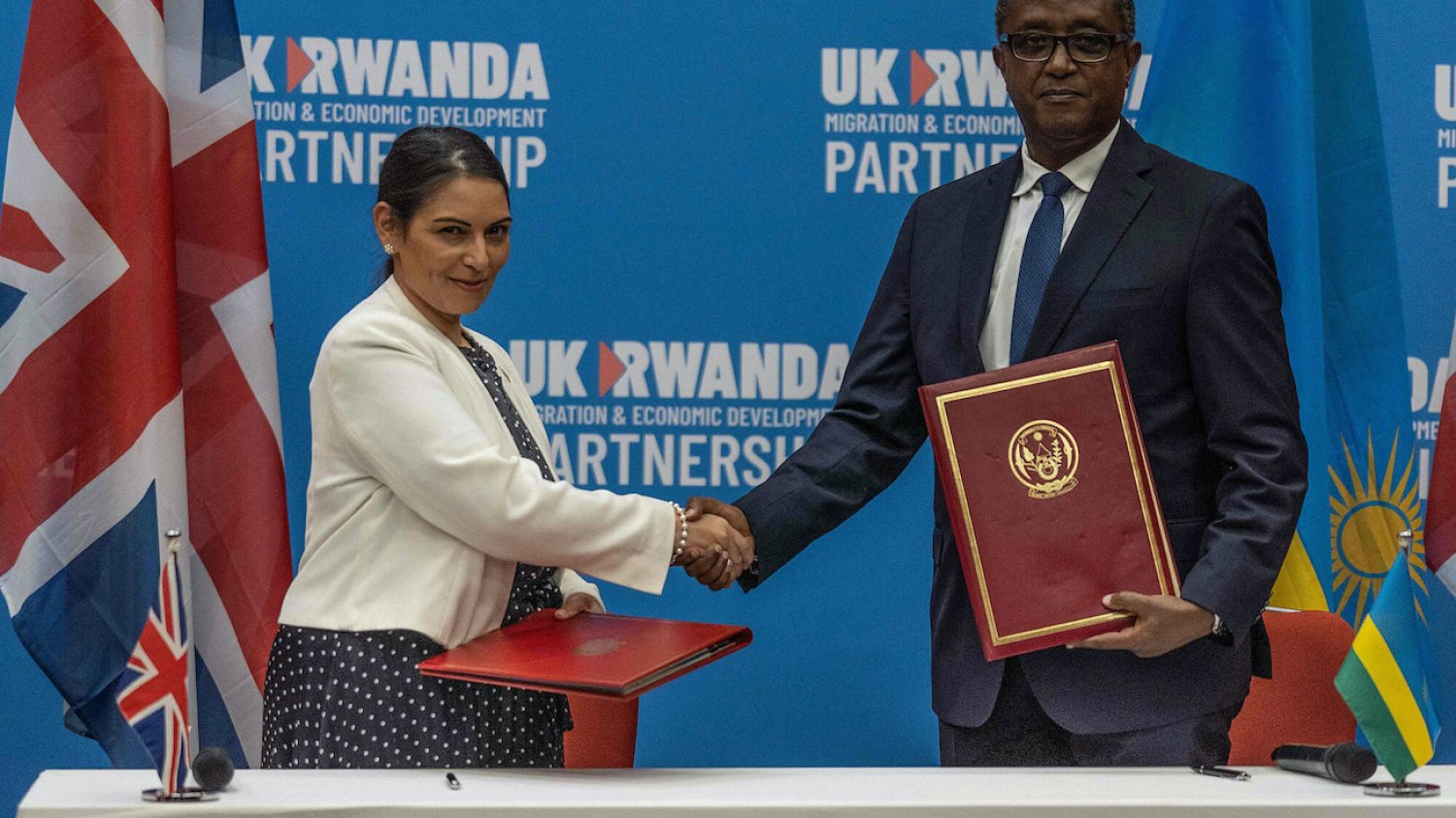 Priti Patel (brytyjska minister spraw wewnętrznych) i Vincent Biruta (rwandyjski minister spraw zagranicznych i współpracy międzynarodowej). 14 kwietnia podpisali porozumienie o wysyłaniu uchodźców z Wielkiej Brytanii do Rwandy. Priti Patel (brytyjska minister spraw wewnętrznych) i Vincent Biruta (rwandyjski minister spraw zagranicznych i współpracy międzynarodowej). 14 kwietnia podpisali porozumienie o wysyłaniu uchodźców z Wielkiej Brytanii do Rwandy.