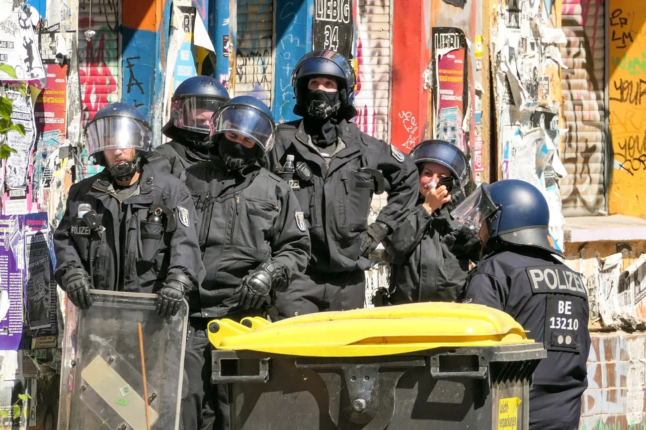 Niemieccy policjanci w kaskach i z tarczami.
