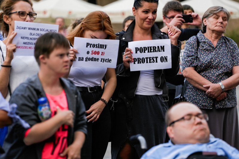 Wrzesień 2018, rodzice niepełnosprawnych protestują w Krakowie. Od 1 marca 2019 r. Kraków wprowadza 500 zł dla opiekunów niepełnosprawnych dorosłych.