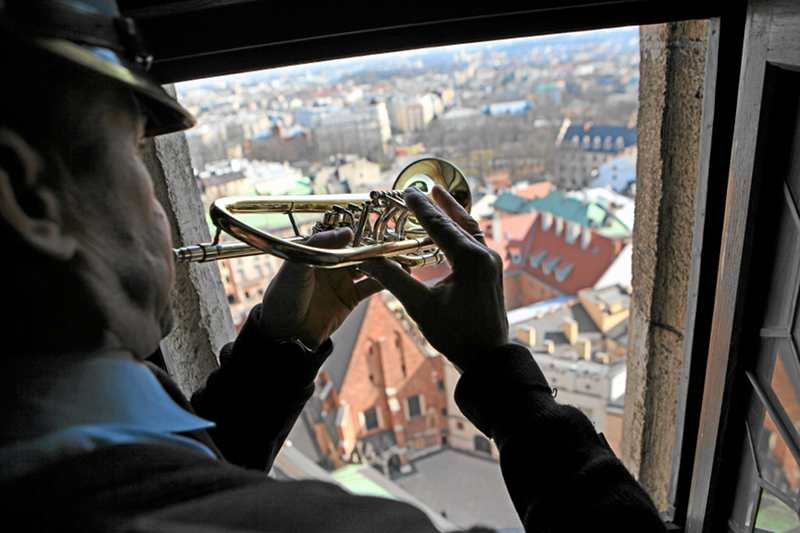 Strażak odgrywa hejnał mariacki z wieży Kościoła Mariackiego w Krakowie