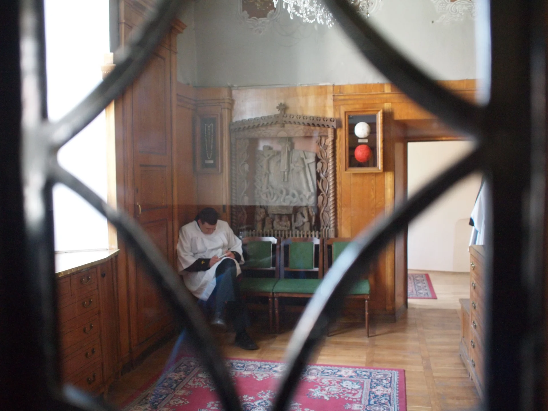 Ministrant w zakrystii kaplicy Matki Boskiej Ostrobramskiej czeka na kolejną mszę świętą.