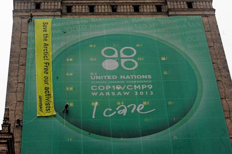 Aktywiści Greenpeace'u zasłaniają płachtę reklamującą szczyt klimatyczny własnym banerem. Całą akcja miała miejsce 21.11.2013, podczas Szczytu Klimatycznego ONZ w Warszawie.