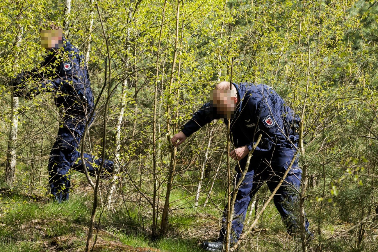 Dwaj mężczyźni przeszukujący krzaki