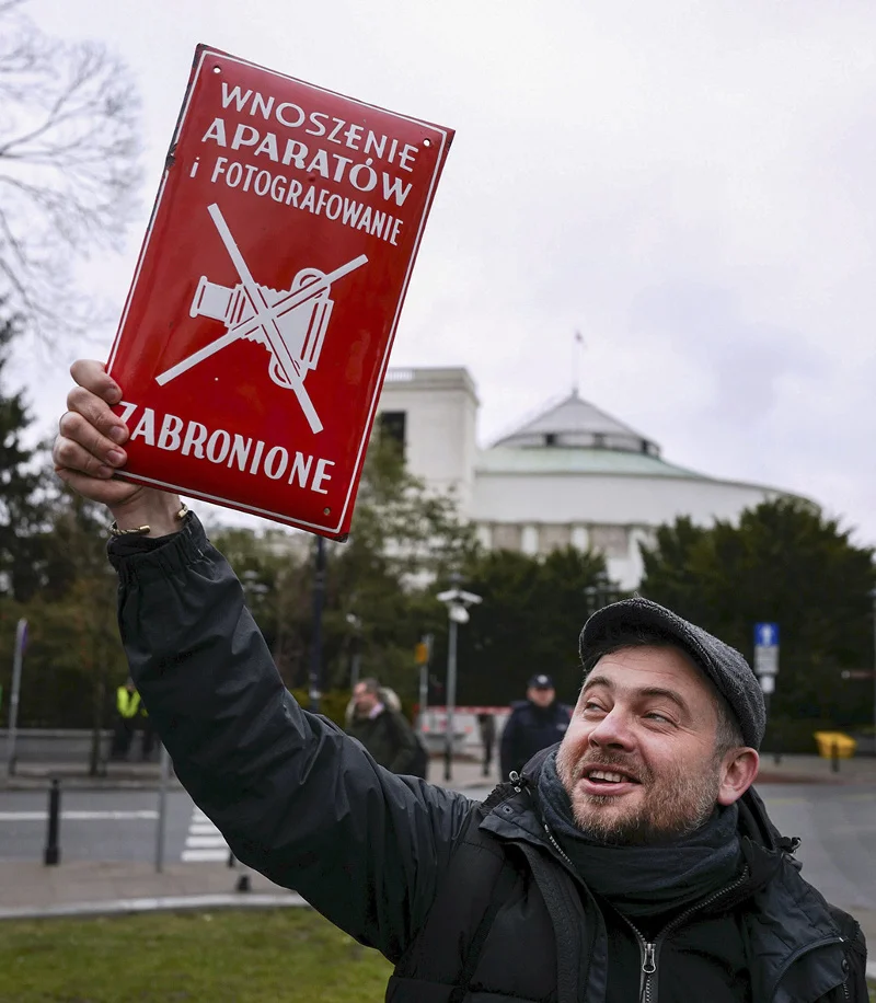 Mężczyzna manifestujący przeciwko ograniczeniu swobody mediów w parlamencie przez PiS.
