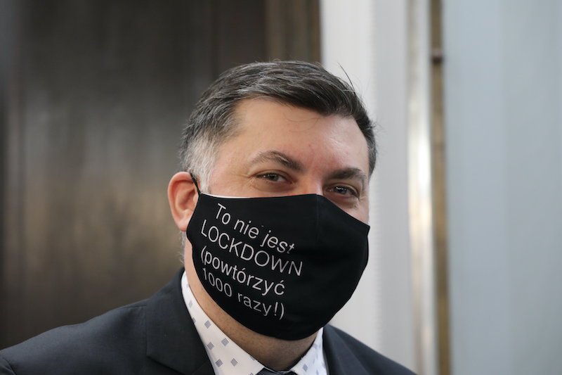 Poseł Artur Dziambor (Konfederacja) w maseczce z napisem "To nie jest LOCKDOWN (powtórzyć 1000 razy!)".