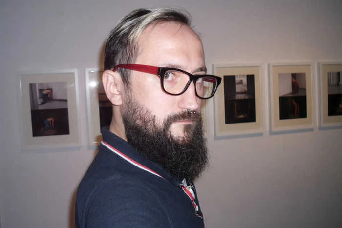 Paweł Żukowski na tle swojego cyklu do wystawy "Tribute to Moda Polska"