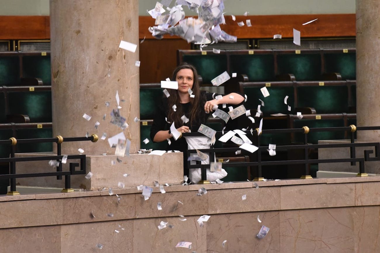 Posłanka Klaudia Jachira rozrzuca wydrukowane "banknoty" z galerii sejmowej przeciwko kolejnej kadencji Adama Glapińskiego na stanowisku prezesa Narodowego Banku Polskiego. Został na nie wybrany głosami posłów PiS.