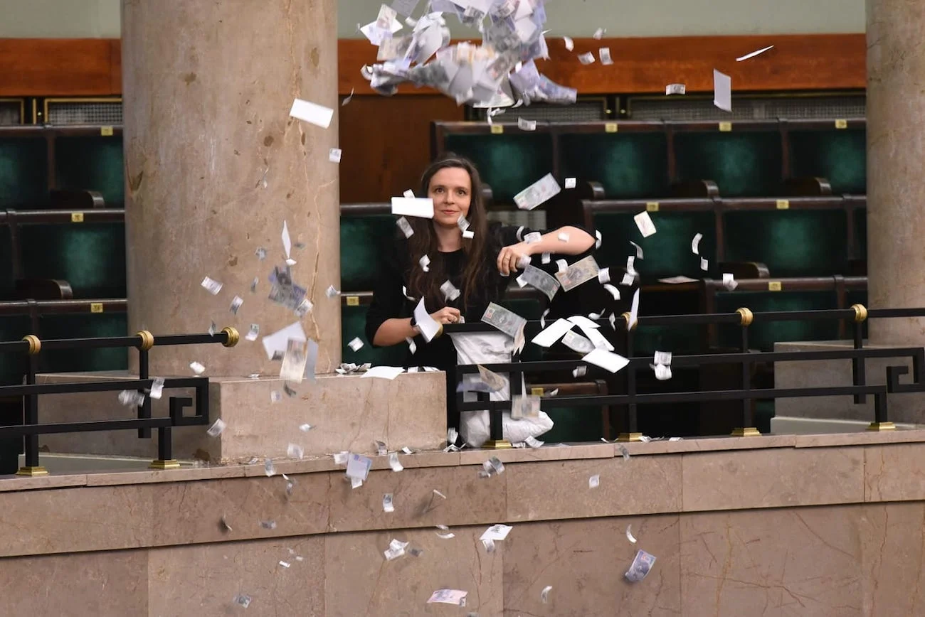Posłanka Klaudia Jachira rozrzuca wydrukowane "banknoty" z galerii sejmowej przeciwko kolejnej kadencji Adama Glapińskiego na stanowisku prezesa Narodowego Banku Polskiego. Został na nie wybrany głosami posłów PiS.