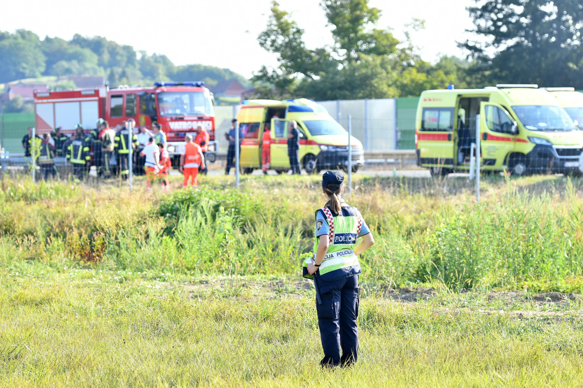 Droga do Chorwacji jest niebezpieczna Wypadek drogowy w Chorwacji. Na pierwszym planie policjantka, dalej służby ratunkowe w akcji na autostradzie.