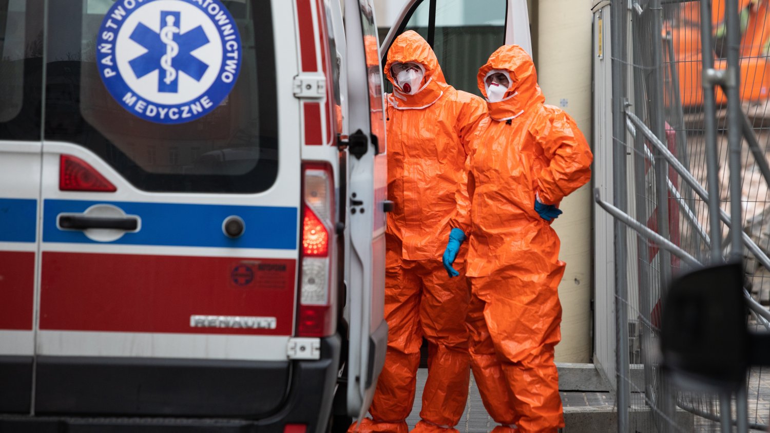 Ratownicy w kombinezonach dowożą ambulansem do szpitali zakaźnych osoby zakażone koronawirusem.