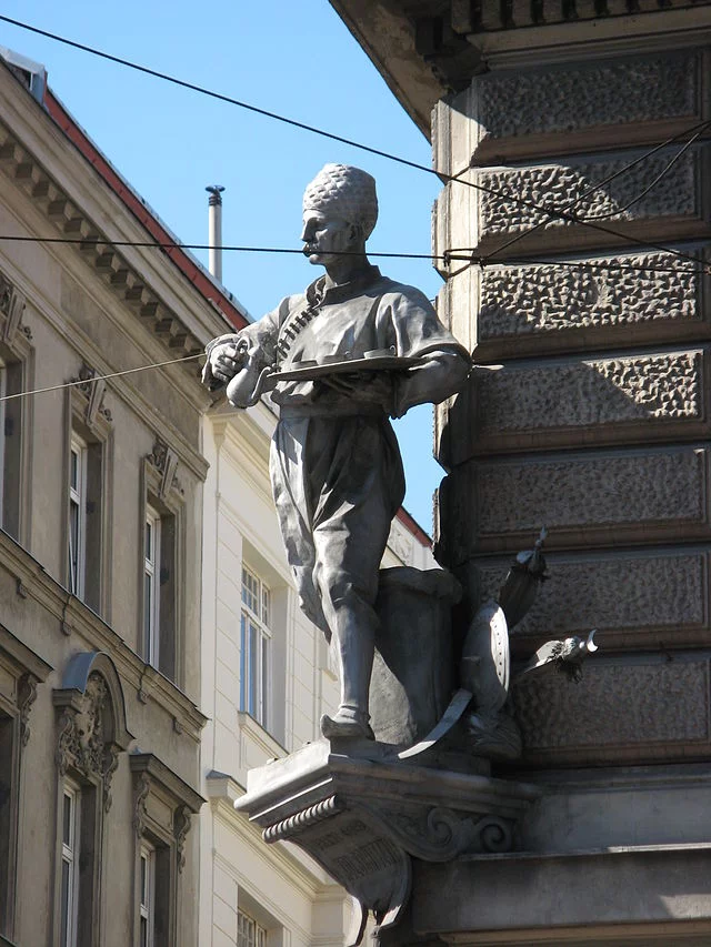 Pomnik na narożniku domu w Wiedniu, wyobrażający Kulczyckiego w stroju, w jakim podawał kawę.