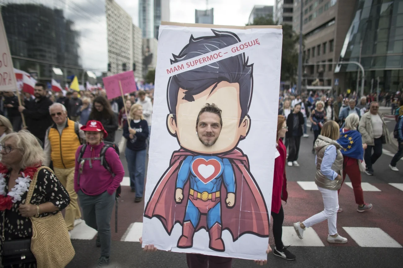 Mężczyzna pozujący do zdjęcia jako suberbohater. Nad nim napis: mam supermoc - głosuję.