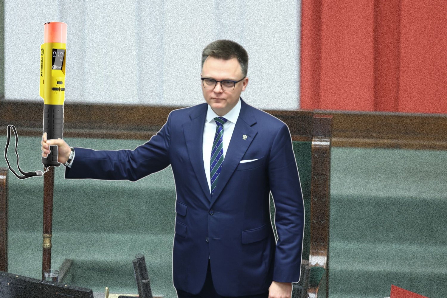 Marszałek Szymon Hołownia z laską marszałkowską w ręku. Na jej szczycie komputerowo został dodany alkomat.