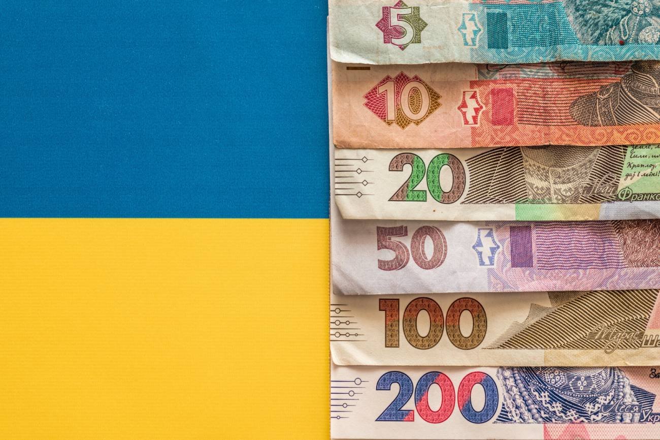 Hrywny na tle flagi Ukrainy.