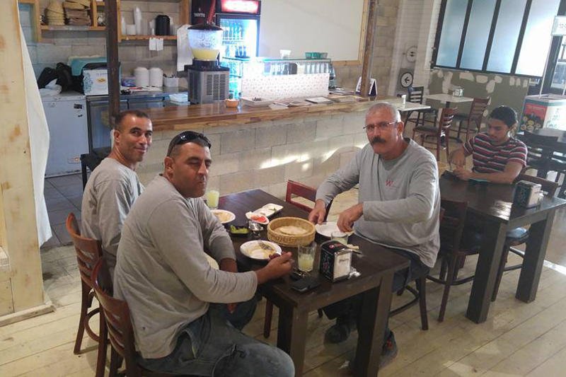 Arabowie i Żyd jedzą humus w izraelskiej kawiarni.