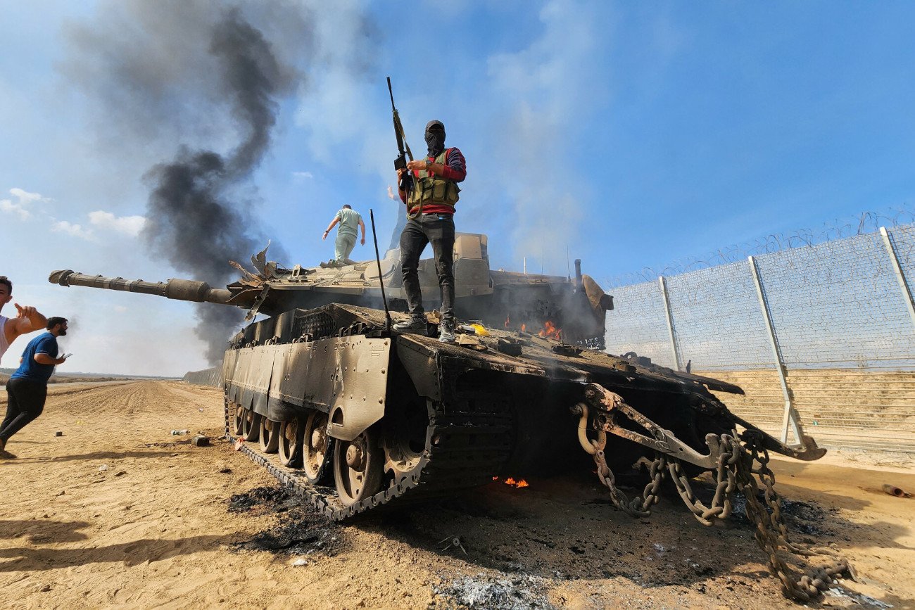 Bojownik zbrojnego skrzydła Hamasu na zniszczonym czołgu sił izraelskich w Gazie